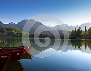 Červené člny v horskom jazere vo Vysokých Tatrách. Štrbské pleso, Slovensko, Európa