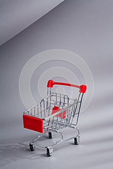 Red bogie, dolly, customers truck, shopping trolley on white background. Discount, sale, consumption, marketing consept. Vertical