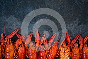 Red boiled crawfishes on table in rustic style, closeup. Lobster closeup
