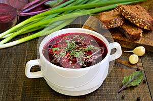 Red borscht soup with dill in white bowl