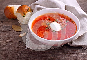 Red borscht soup in white bowl