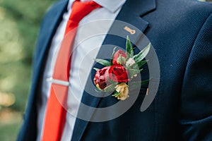 Red boutonniere on suit of groom