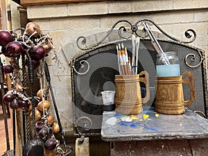 Red bow near the fireplace on an iron stand for a poker fire spatulas village house country house folk utensils arts and