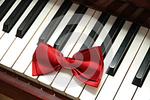 Red bow tie on white piano key