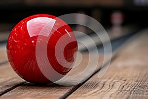 A red bowling ball sitting on top of a wooden table