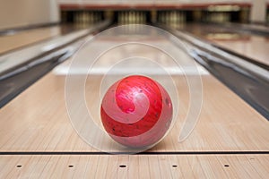 Red bowling ball on the track in the bowling center