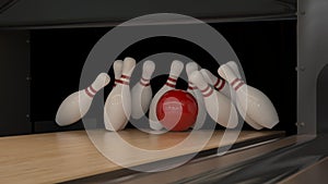 Red bowling strike ball on a wooden track with pins