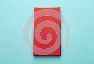 Red box product packaging isolated on blue background. Flat lay Top view.