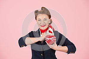 A Red box with ribbon in hand of brunette woman. Box for present in hand of beautiful airhostess. Valentine concept female