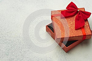 Red box with ribbon on a light background. Gift wrapping with empty place for text