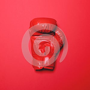 Red boxing glove on red background - Flat lay