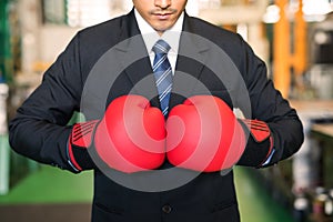 Red boxing gloves on factory owner hands