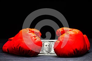 Red boxing gloves holding the dollar banknote.