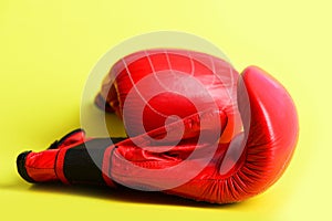 Red boxing gloves on juicy yellow background