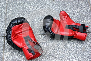 Red boxing gloves lying on the street