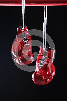 Red boxing gloves on a ring. black background