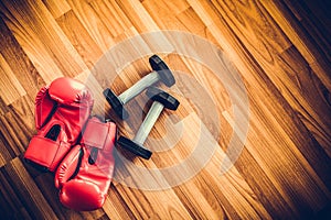 Red boxing gloves on a wood background