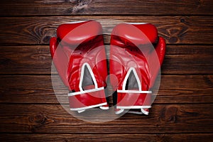 Red boxing gloves on wooden background