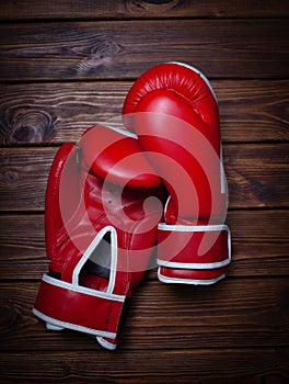 Red boxing gloves on wooden background