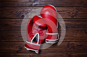 Red boxing gloves on wooden background