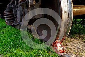 Red brake shoe under the wheel of a freight car on the siding