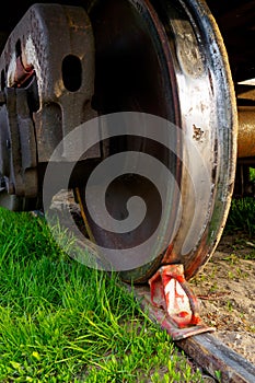 Red brake shoe under the wheel of a freight car on the siding