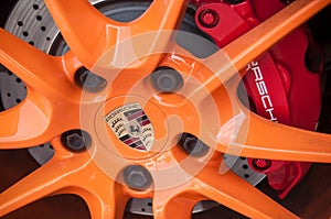 Red break on orange wheel of Porsche 911 sport car