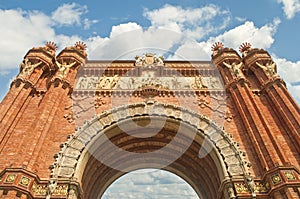 Red brick arch against blue sky on sunny day photo