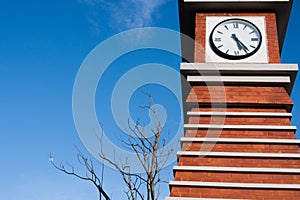 red brick block clock tower in blue clear sky