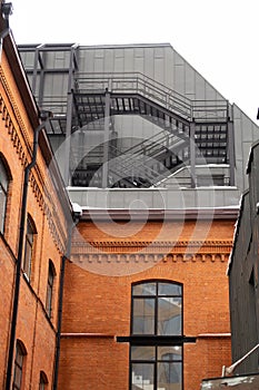 Red brick building with metal staircase on the roof, architectural background