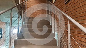 Red brick building with a modern staircase in a loft style with metal railing. Stairs adorn the building. Modern stairwell. Steel