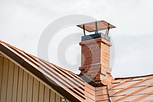Red brick chimney with a metal roof