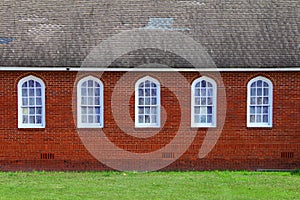 red brick christian Baptist religious church stained glass windows building facade retro style window roofline countryside rural
