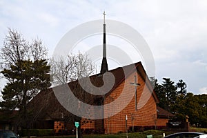 Red Brick Christian Church Against Cloudy Sky