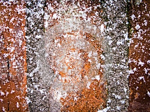 Red brick concrete wall covered with snowflakes