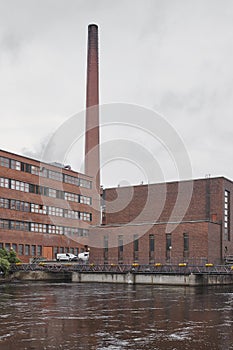 Red brick factory building with chimney in Tampere. Finland