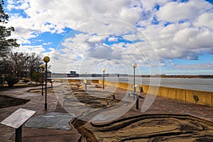 A red brick footpath through Mud Island Park near the vast waters of the Mississippi river and a bridge over the water