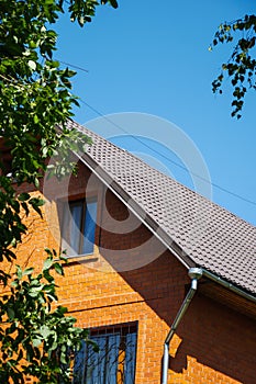 Red brick house with drainage and decorative window grates