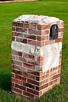Red Brick mailbox with green grass in background.