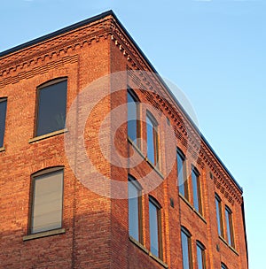 Red brick office building corner in sunlight blue sky