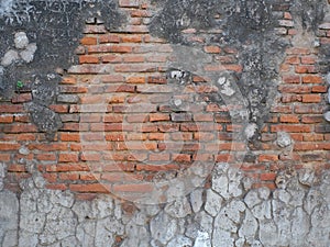 Red brick pattern with a rough texture and a peeling cement wall due to its old age