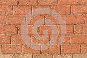 Red brick pavement texture with a regular, rectangular pattern.