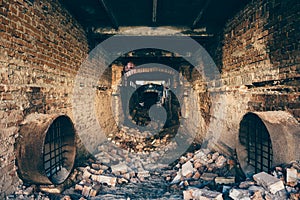 Red brick ruined abandoned underground sewer tunnel with dramatic mysterious atmosphere, inside sewerage