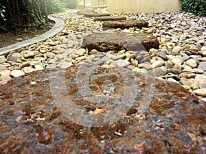 Red brick stone footpath step low angle view on small rock in the garden.