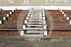 Red brick tribune, concrete staircase, benchs for seating of a public sports stadium, bottom view