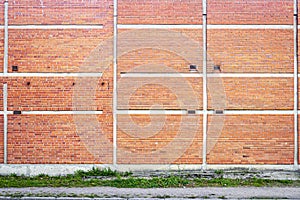 Red brick wall background with green grass