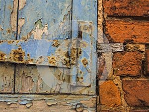 Red brick wall with blue wood window, detail.