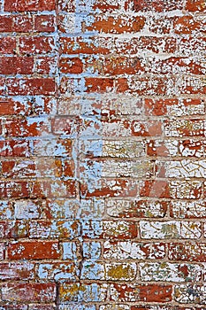 Red brick wall covered in chipped, cracked, and flecks of white and blue paint, background asset