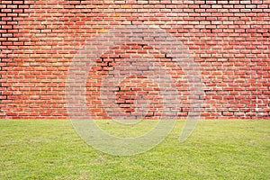 Red brick wall with green grass