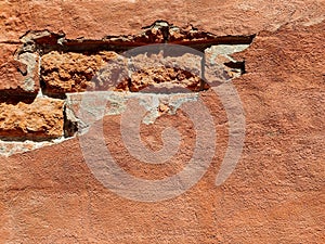 Red brick wall of an old building with crumbling plaster. Copy space.